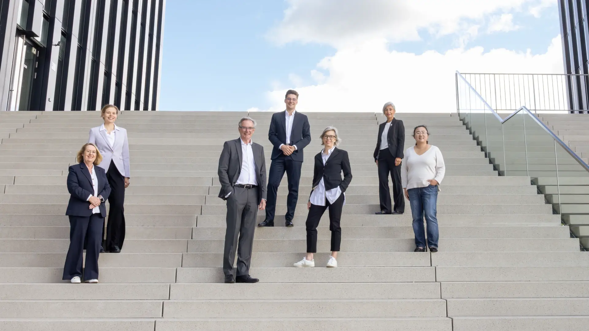 das Team von H&W steht auf einer Treppe im Düsseldorfer Hafen